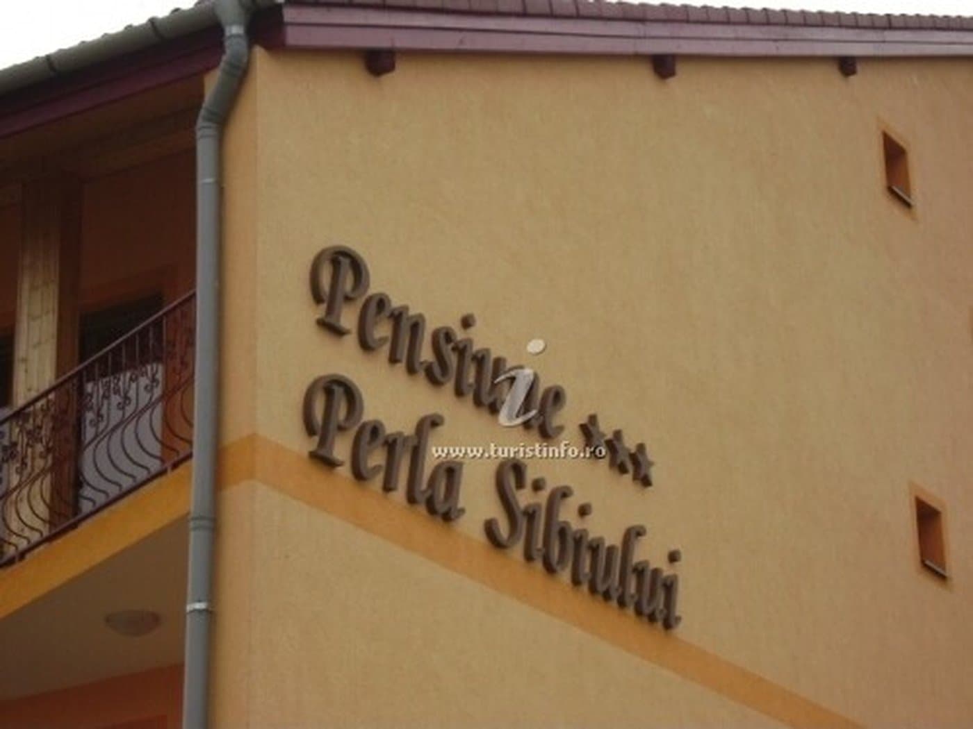 Firma pictată «Pensiune Perla Sibiului» pe fațada clădirii